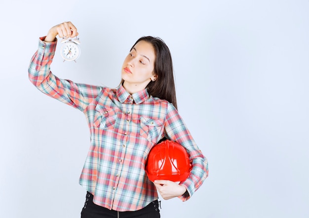 Een jonge vrouw met een helm en een wekker.