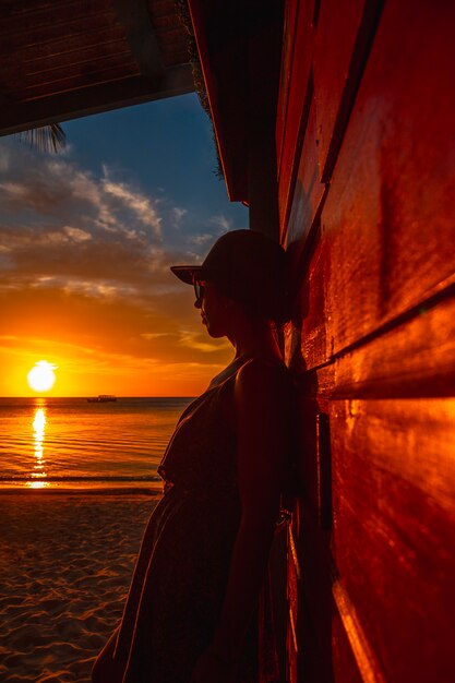 Een jonge vrouw met een pet op West End Sunset in de Caribische Zee, Roatan Island. Honduras