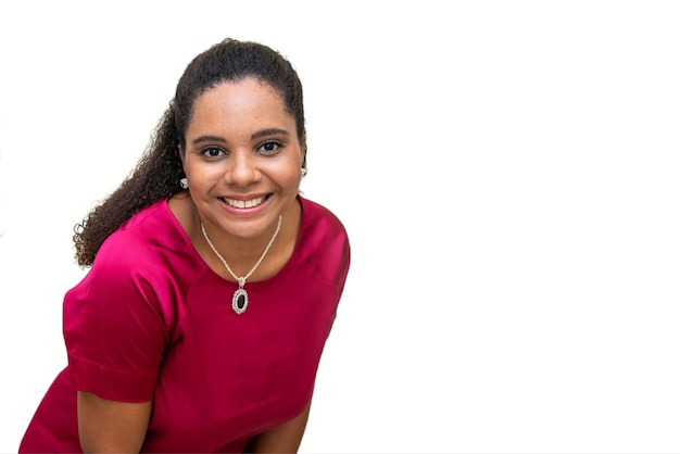 Een jonge vrouw met een roze shirt en een ketting lacht.