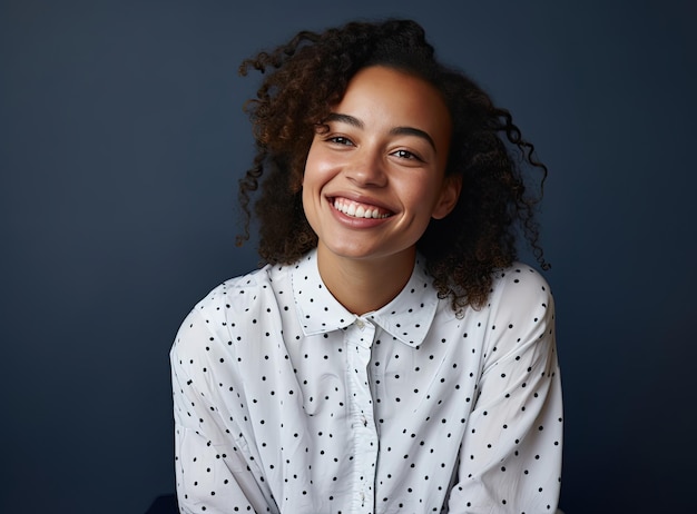 Een jonge vrouw met krullend haar, gekleed in een polkadotshirt