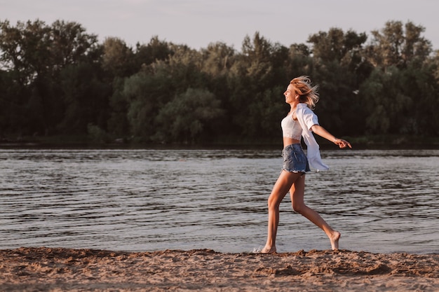 Een jonge vrouw met vrijheid tegen de achtergrond van de rivier en bomen profielfoto een mooie...