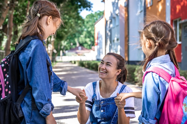 Een jonge vrouw ondersteunt de dochters moreel, hand in hand, moedigt de kinderen aan en begeleidt de leerlingen naar school.