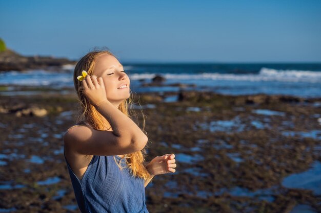 Een jonge vrouw op een rotsachtige kosmische kust van Bali