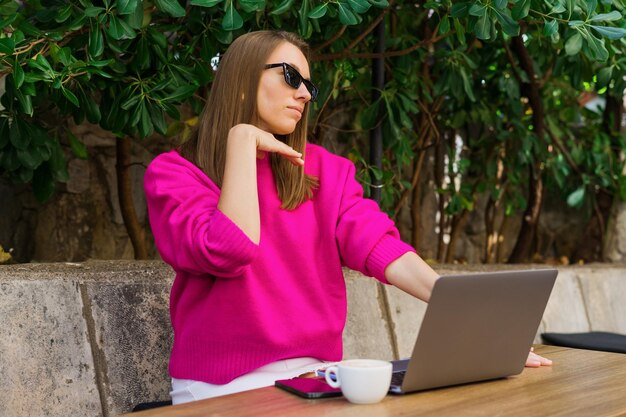 Een jonge vrouw poseert in een zomercafé Zomerwerkdag buiten het kantoor