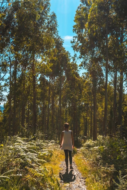 Een jonge vrouw slentert langs het pad tussen de bomen in het natuurpark Listorreta