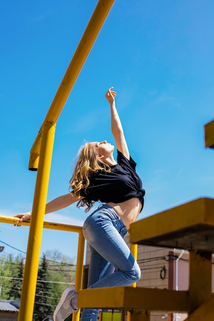 Een jonge vrouw staat op het balkon en danst Een actief en energiek meisje