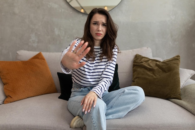 Een jonge vrouw toont met haar hand het symbool nee