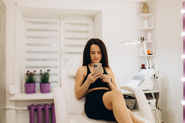 Een jonge vrouw wacht op laserontharing in een schoonheidssalon