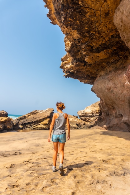 Een jonge vrouw wandelen langs de zee in Playa de Garcey, westkust van Fuerteventura, Canarische Eilanden. Spanje