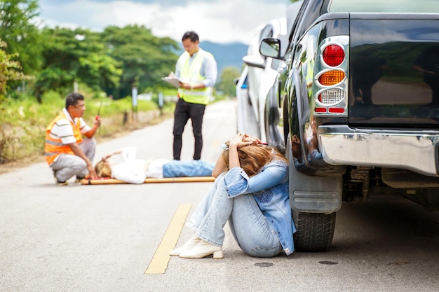 Een jonge vrouw zit huilend naast de auto die ze op de weg tegen iemand heeft aangereden