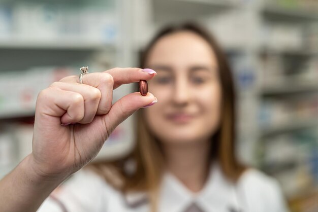 Een jonge vrouwelijke apotheker leest medicijninstructies terwijl ze in het gangpad van de apotheek staat