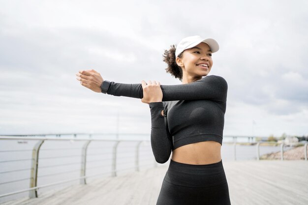 Een jonge vrouwelijke atleet doet fitness-actieve trainingsoefeningen voor cardio en gebruikt een slimme horloge-tracker op haar hand