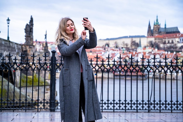 Foto een jonge vrouwelijke toerist in praag maakt een selfiefoto om online te delen