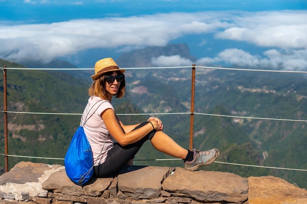 Een jonge vrouwelijke toerist zit aan de Miradouro do Juncal op Pico do Arieiro Madeira Portugal