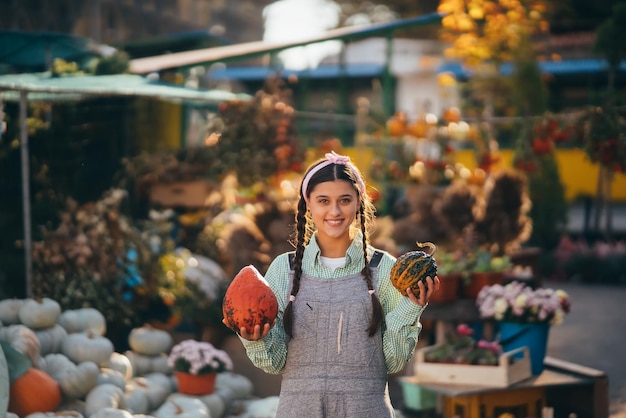 Een jonge vrouwelijke verkoper toont de herfstoogst