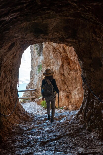 Een jonge wandelaar in de tunnel van het pad in het natuurpark Penon de Ifach met de stad Calpe op de achtergrond Valencia Spanje Middellandse Zee Uitzicht op het strand van La Fossa