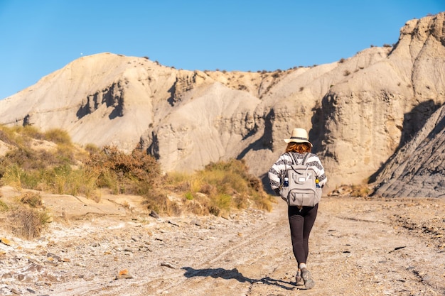 Een jonge wandelaar met rugzak en strohoed in de woestijn van Tabernas, provincie AlmerÃƒÂƒÃ‚Âa, Andalusië. Op trektocht in de Rambla del Infierno