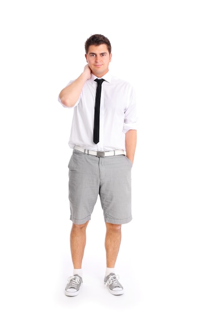 een jonge zakenman die in korte broek tegen een witte achtergrond staat