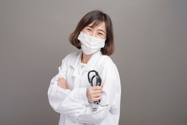 Een jonge zekere vrouwelijke arts draagt chirurgisch masker
