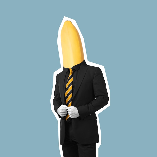 Een jonge zelfverzekerde zakenman met banaan aan het hoofd in een zwart pak en gestreepte gele stropdas