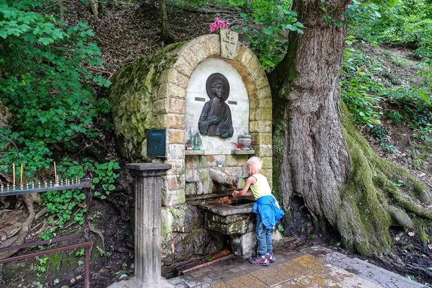 Een jongen bij een bron met geneeskrachtig water in een resortpark Dante's Gorge Hot Spring Russia 2021
