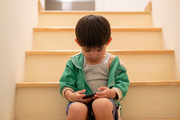 Een jongen die door zijn moeder werd uitgescholden, kwam stiekem op de trap aan de telefoon spelen