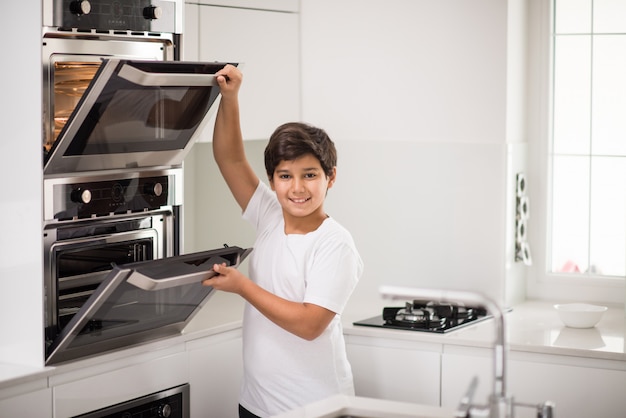 Een jongen die zich in nieuwe moderne keuken bevindt