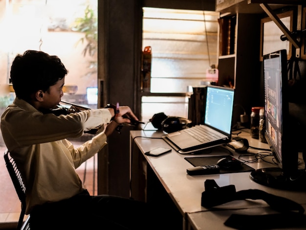 een jongen die zijn viool oefent voor een computer thuis