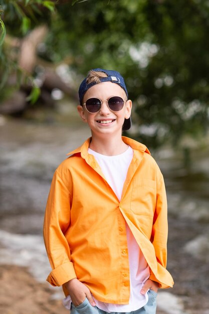 Een jongen in een oranje shirt aan de kust