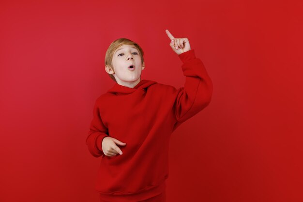 Een jongen in een rood trainingspak kwam met een idee en stak zijn vinger op en omhoog