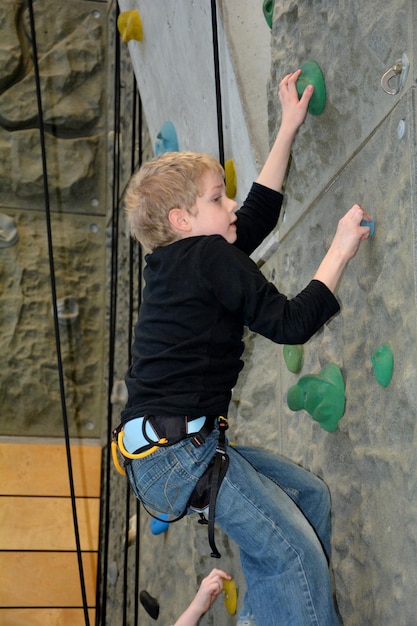 Foto een jongen klimt in een klimhal.