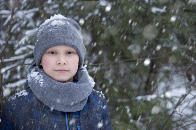 Een jongen loopt in de winter in het bos