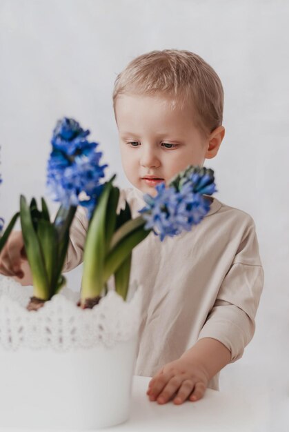 een jongen met bloemen het kind zorgt voor de bloemen blauwe hyacint