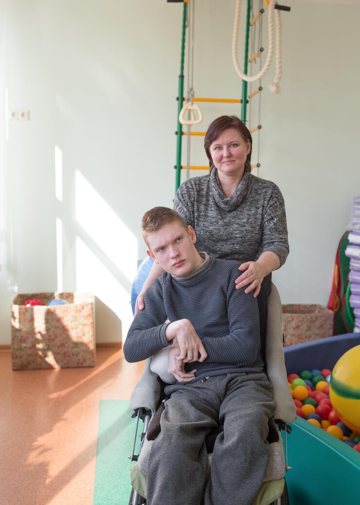 Een jongen met een handicap in een rehabilitatiecentrum voor mensen met speciale behoeften naast zijn moeder