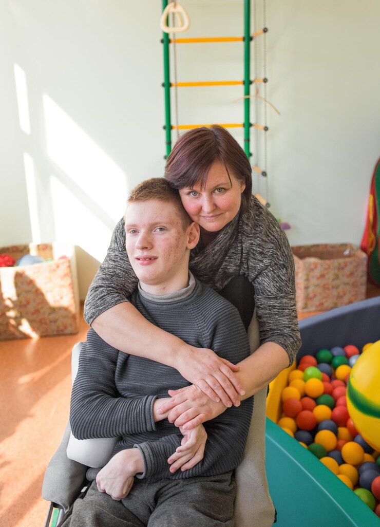 Een jongen met een handicap in een rehabilitatiecentrum voor mensen met speciale behoeften naast zijn moeder