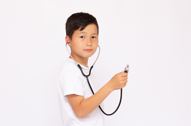 Een jongen met een stethoscoop in een wit oppervlak