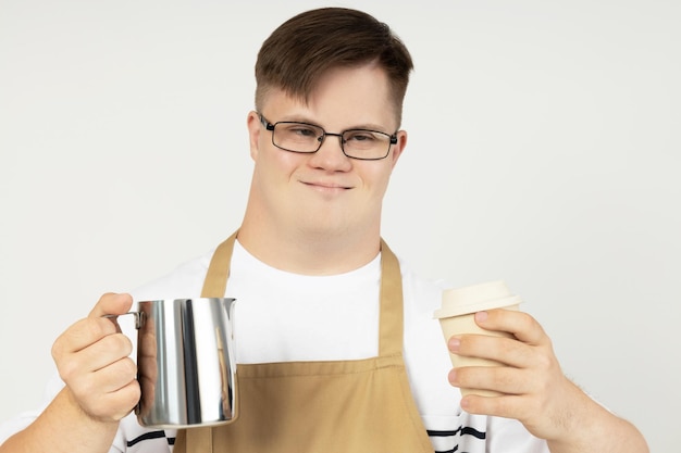 Foto een jongen met het down-syndroom als barista in een schort en met koffie