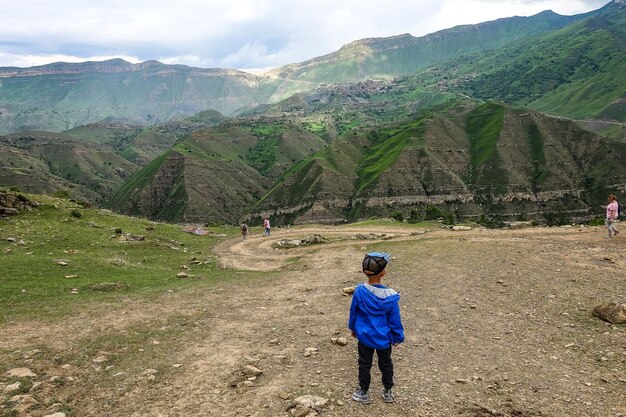 Een jongen op de achtergrond met uitzicht op de bergen van Dagestan bij het dorp Gamsutl, Rusland juni 2021