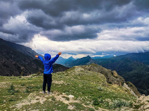 Een jongen op de achtergrond van een adembenemend uitzicht op de bergen tijdens een onweersbui in Dagestan Kaukasus Rusland