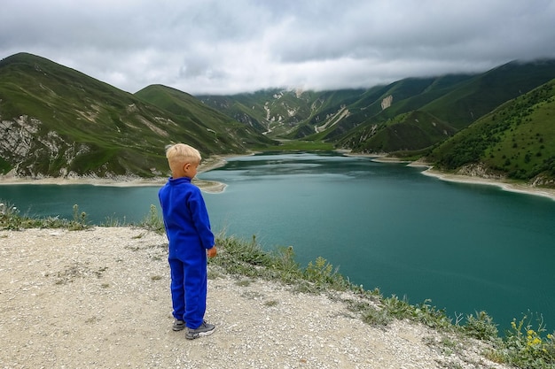 Een jongen op de achtergrond van het Kezenoyam-meer in de bergen van de Kaukasus in Tsjetsjenië, Rusland juni 2021