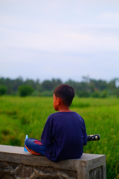 Een jongen rijdt op een scooter in een veld