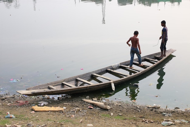 Een jongen staat op een boot in het water.