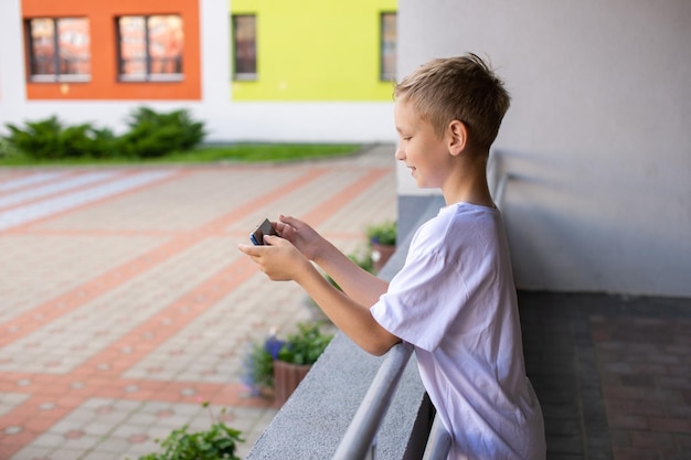 Een jongen staat op straat met een telefoon