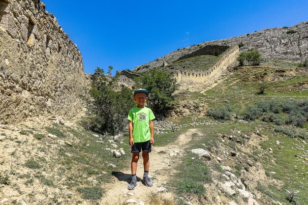 Een jongen tegen de achtergrond van het Gunib-fort Een beschermende muur Rusland Dagestan juni 2021