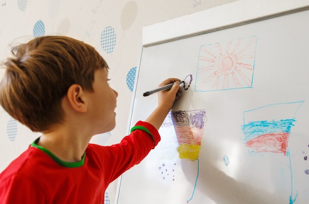 Een jongen trekt op een schoolbord