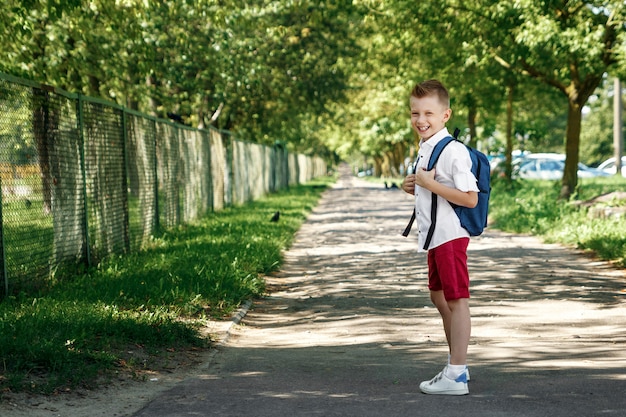 Een jongen uit een lagere school met een rugzak op straat