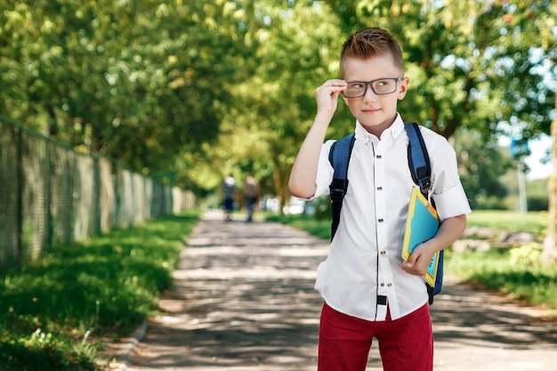 Een jongen uit een lagere school met een rugzak op straat