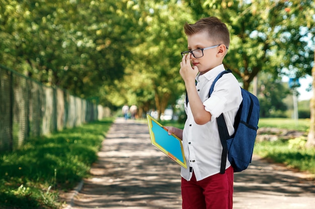 Een jongen uit een lagere school met een rugzak op straat