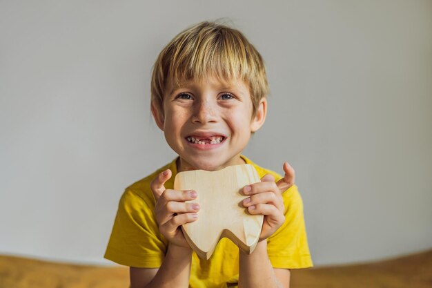 Een jongen van 6 jaar oud heeft een doos voor melktanden Tandenwissel