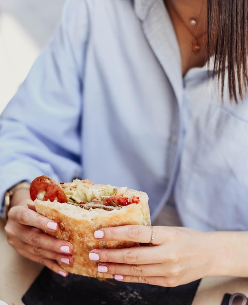 Een jongere geniet van een broodje rundvlees